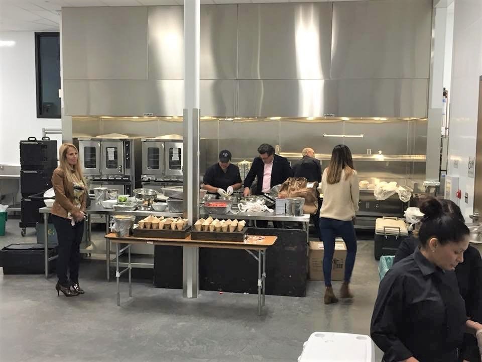 Bellflower Events Center kitchen with people preparing food.