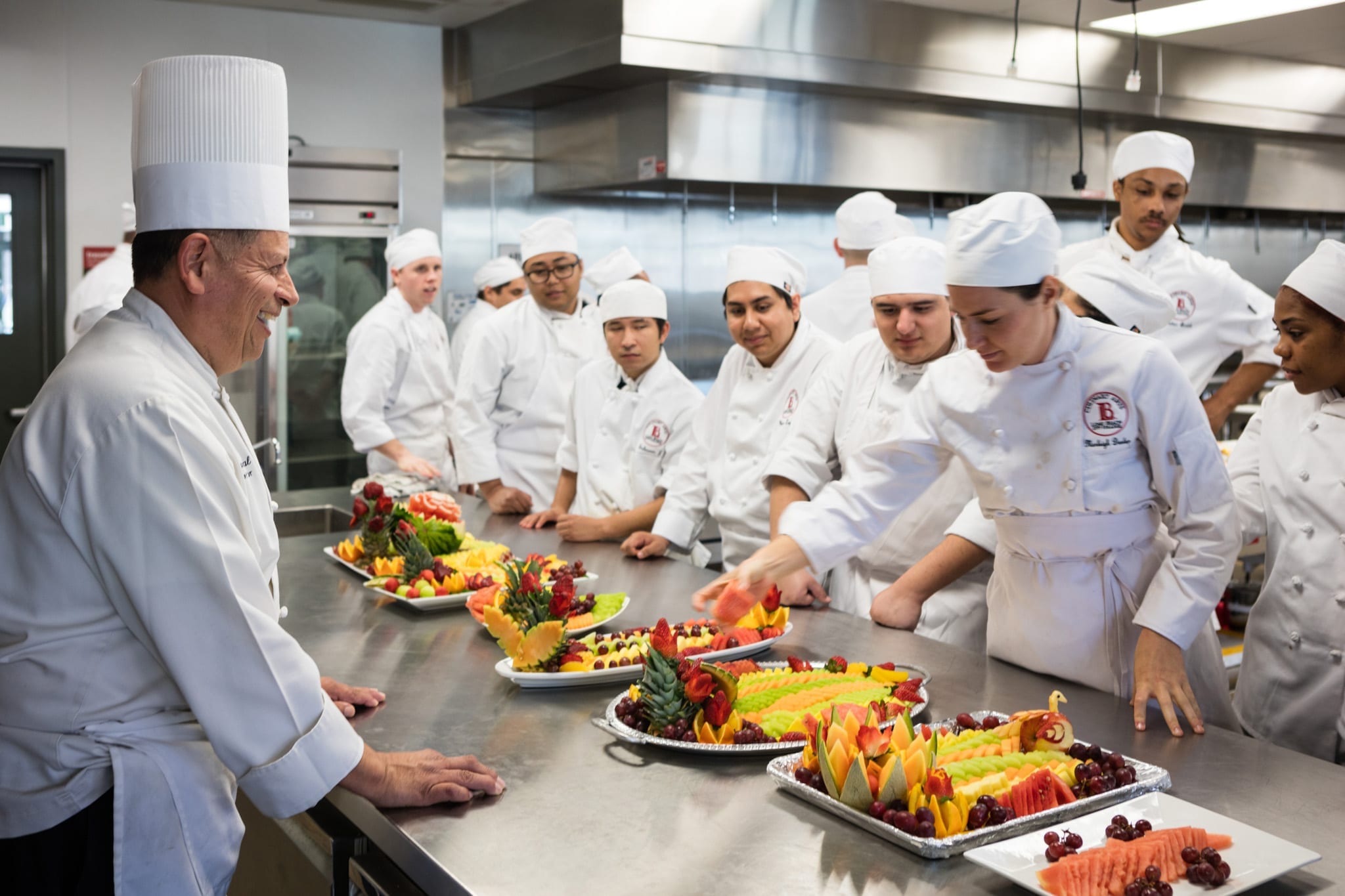 Long Beach City College. Chefs gather around fruit platters.