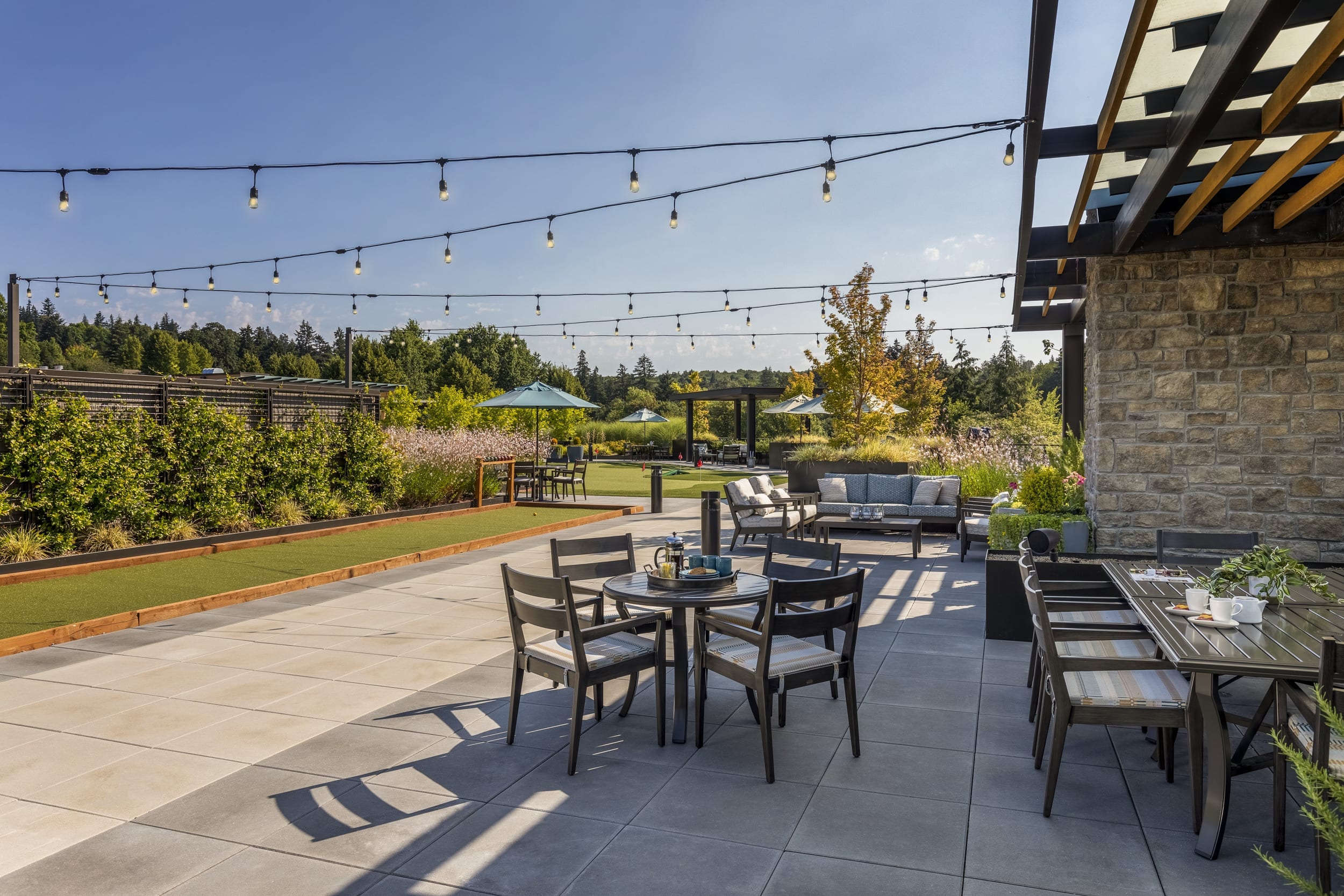 The Springs Living outdoor patio with string lights and seating.