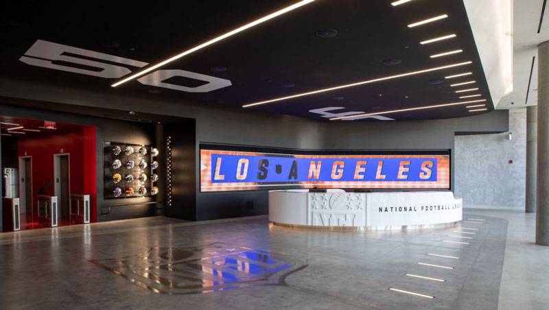 NFL Los Angeles Commissary. Modern lobby with the NFL logo on the floor and elevators at the far end of the room.