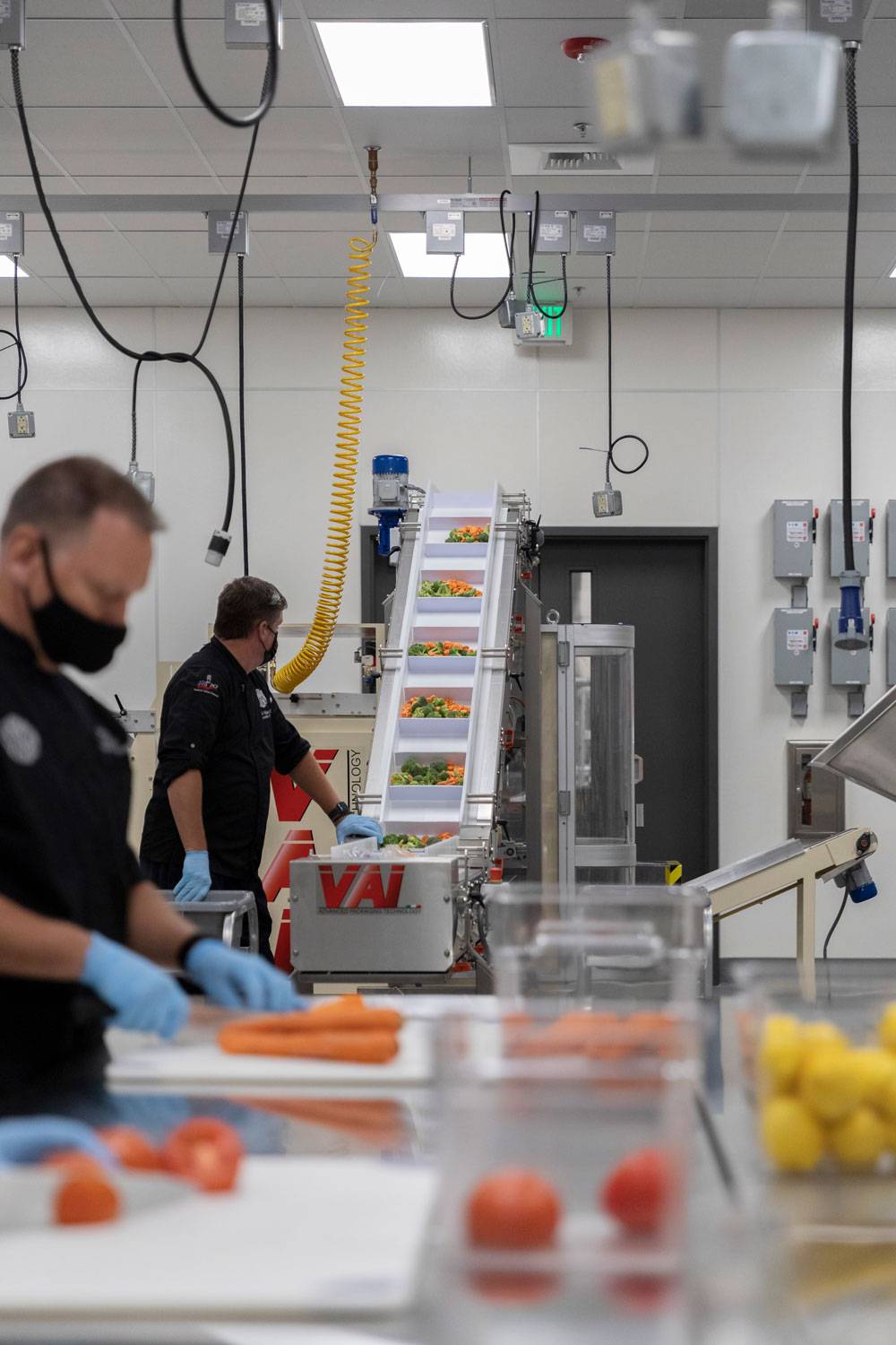 Sacramento City Unified School District. Chefs work with fresh vegetables in an assembly line.