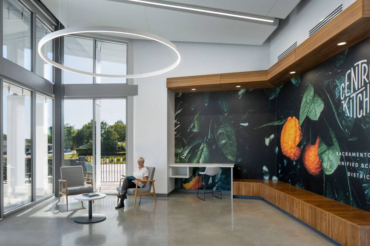 Sacramento City Unified School District. Sitting area with high ceilings and a Central Kitchen mural on wall.
